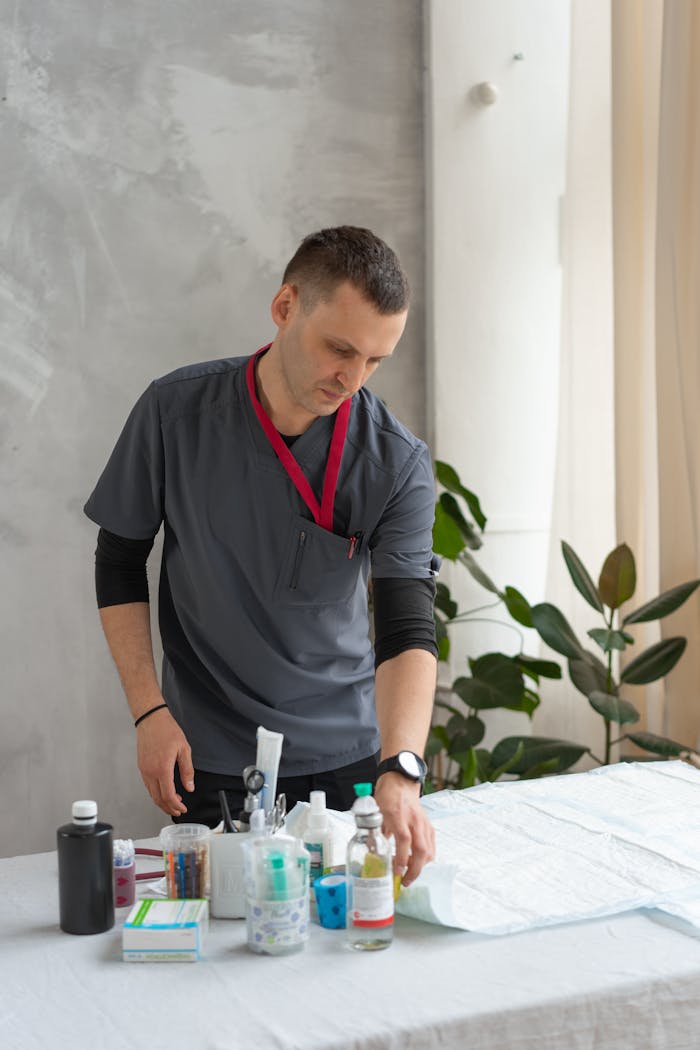 about-us A veterinarian in scrub suit arranges equipment on a table indoors.